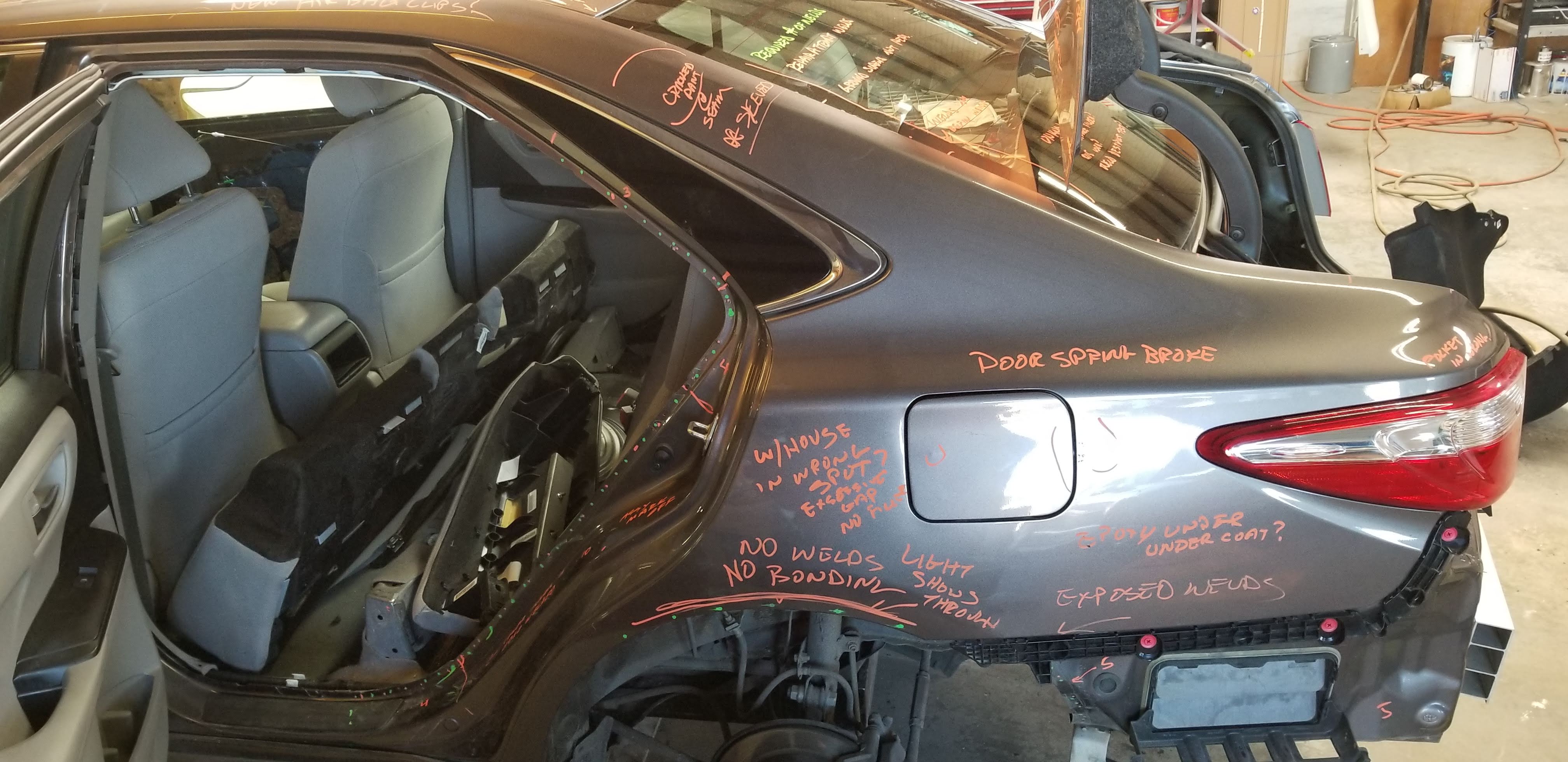 Toyota Camry post-repair inspection showing multiple problems written in orange marker — Rusty's Bodywerks
